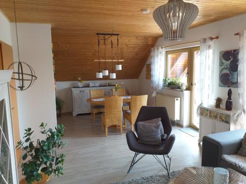 sala de estar con silla y comedor en Ferienwohnung 'am Bienwald', en Schaidt