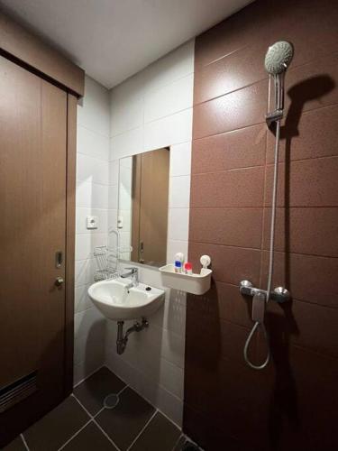 La salle de bains est pourvue d'un lavabo et d'un miroir. dans l'établissement West Jakarta Gem Modern Studio at Puri Orchard, à Jakarta