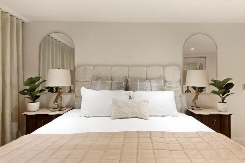 a bedroom with a large white bed with two lamps at Hububb Luxury Apartment Kensington in London