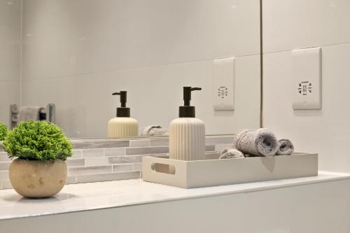 ein weißes Badezimmer mit 2 Waschbecken und einem Spiegel in der Unterkunft Hububb Luxury Apartment Kensington in London