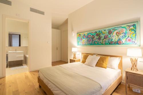 a bedroom with a bed and a painting on the wall at Santa Tecla Living Washington Building in Milan