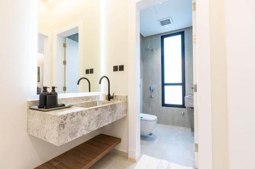 un bagno con lavandino e WC di Amber Hospitality - Qurtubah a Riyad