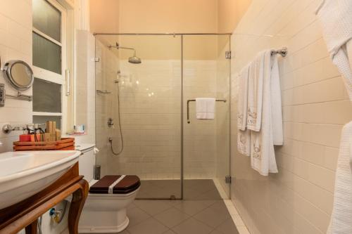 een badkamer met een douche, een toilet en een wastafel bij Castle Hill Bungalow in Kandy
