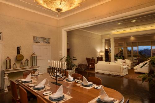 a dining room with a table and a living room at Castle Hill Bungalow in Kandy