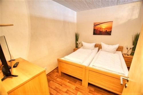 - une chambre avec 2 lits et une télévision dans l'établissement Ferienpark - Haus G, App 0G1108, à Heiligenhafen