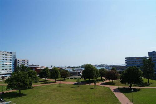 um parque com árvores, relva e edifícios em Ferienpark - Haus H, App 0H0404 em Heiligenhafen