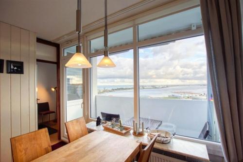 ein Esszimmer mit einem Tisch und einem großen Fenster in der Unterkunft Ferienpark - Haus G, App 0G1003 in Heiligenhafen