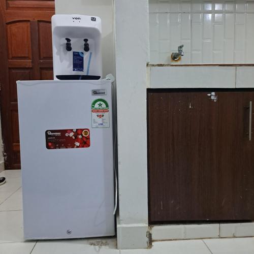 un frigorifero bianco in una cucina accanto a un bancone di Dolphin-holiday homes mombasa a Ndome