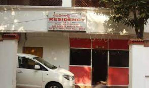 a white car parked in front of a building at Residency 24X7,Bhubaneswar in Bhubaneshwar