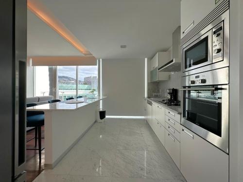 a kitchen with stainless steel appliances and a table at Luxury Apartment in the Center in Funchal