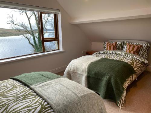una camera da letto con due letti e una finestra di Inishclare Cottages a Killadeas
