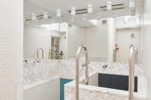 ein Badezimmer mit zwei Waschbecken und einem großen Spiegel in der Unterkunft Vienna Prestige Central Luxury Haven w Free Parking and SAUNA in Wien