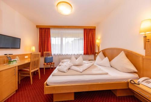 a hotel room with a bed and a desk at Der Schütthof in Zell am See