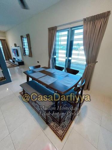 einen Esstisch im Wohnzimmer mit Fenster in der Unterkunft Casa Darfiyya Homestay utk Muslim jer in Teluk Intan