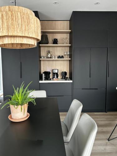 a dining room with a black table and white chairs at Luxury Mountain Retreat with Spa Near Mont Tremblant in La Conception