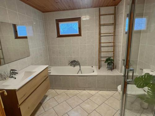 y baño con bañera, lavamanos y ducha. en Le Bercail, en Somme-Leuze