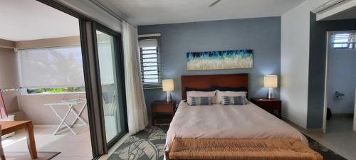 1 dormitorio con cama y ventana grande en Beachwalk Deluxe Apartment - 50 steps to the beach, en Cap Malheureux