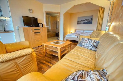 ein Wohnzimmer mit einem Sofa und einem Tisch in der Unterkunft Ferienpark - Haus H, App 0H0709 in Heiligenhafen