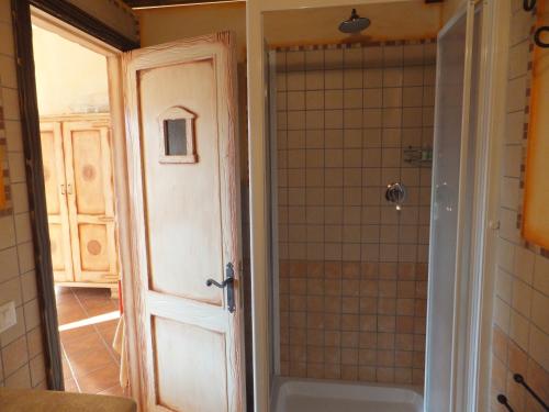 uma casa de banho com um chuveiro e uma porta de vidro em Grazia Deledda em Galtellì
