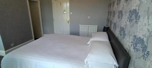 a bed with white sheets and pillows in a bedroom at Riverdale Hall Hotel & Leisure in Bellingham