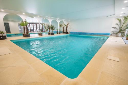 a swimming pool with blue water in a building at Kokořín Apartments in Kokořín
