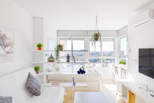 Sun Apartments في توريمولينوس: غرفة معيشة بيضاء مع أريكة وطاولة