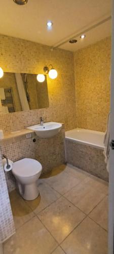 a bathroom with a toilet and a sink and a tub at Riverdale Hall Hotel & Leisure in Bellingham
