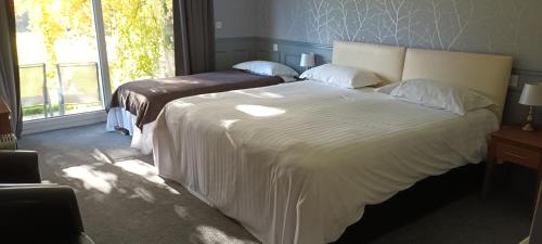 a bedroom with a large white bed and a window at Riverdale Hall Hotel & Leisure in Bellingham