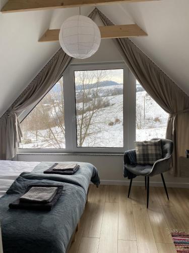 a bedroom with a bed and a large window at Przystanek Przylasek in Grywałd
