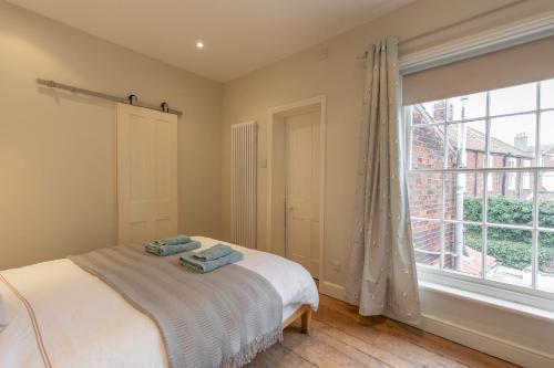 a bedroom with a bed and a large window at 33 Victoria Street in Southwold