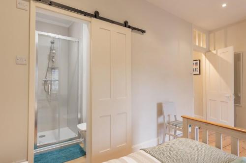 a bathroom with a shower and a sliding door at 33 Victoria Street in Southwold