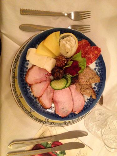 a plate of food with meat and fruit on a table at Pensiunea Casa-Stefanel in Sadova
