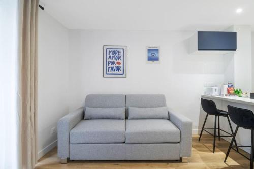 - un canapé gris dans le salon avec une table dans l'établissement 11.Appart 4pers#1 Bedroom#Pigalle#Opéra#Paris 9, à Paris