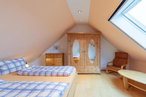 a attic bedroom with two beds and a chair at Kleinwindstein in Neukirchen