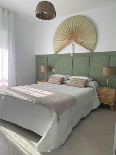 1 dormitorio con 1 cama grande con 2 lámparas y espejo en Soleado y luminoso apartamento, en Fuengirola