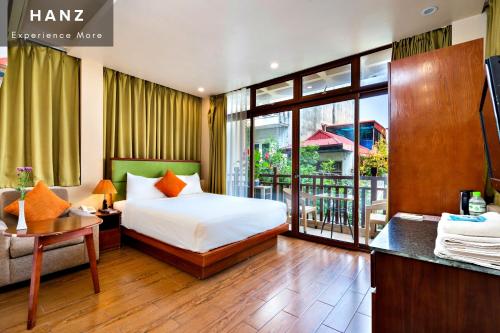 a hotel room with a bed and a balcony at HANZ Artisan Lakeview Hotel Hanoi in Hanoi