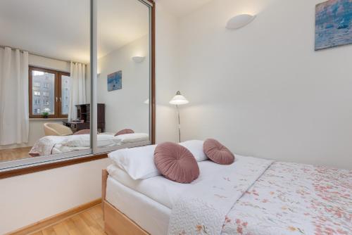 - une chambre avec un lit et un grand miroir dans l'établissement Sienna Family Apartment in the Center of Warsaw by Renters, à Varsovie