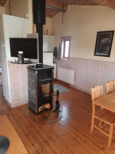 a living room with a stove and a table at Sjötorp säteri & stugby in Larv