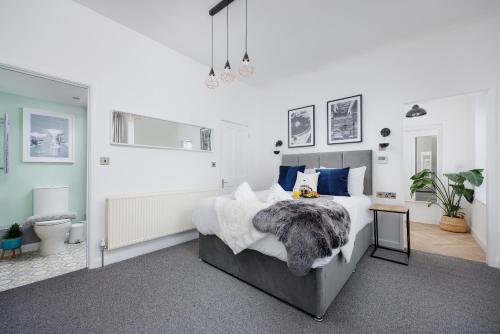 a bedroom with a large bed with blue pillows at Stunning Central Plymouth Studio Apartment - Sleeps 2 - Habita Property in Plymouth
