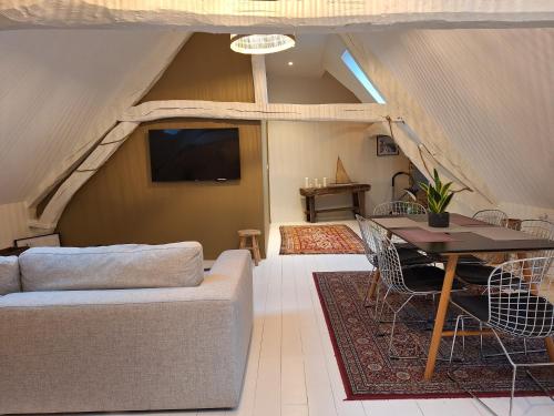 un salon avec un canapé et une table dans l'établissement LE HENRY IV, à Saint-Valery-en-Caux