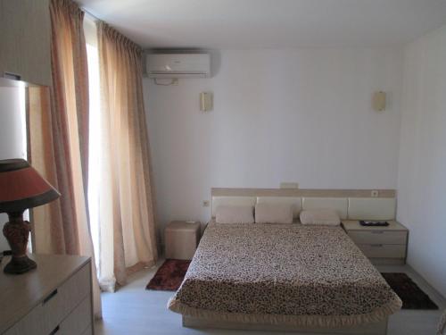a bedroom with a bed and two large windows at Apartment Crystal Beach in Nesebar