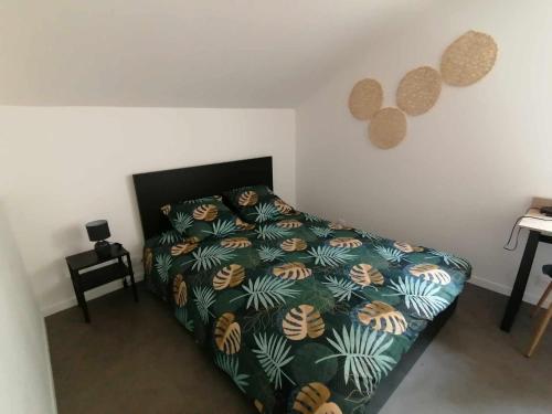 een slaapkamer met een bed met een groen dekbed bij Résidence Duplex in Montbéliard