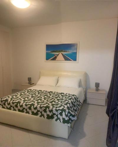 a bedroom with a large bed with a picture on the wall at La casa di Gio' in Fiumicino