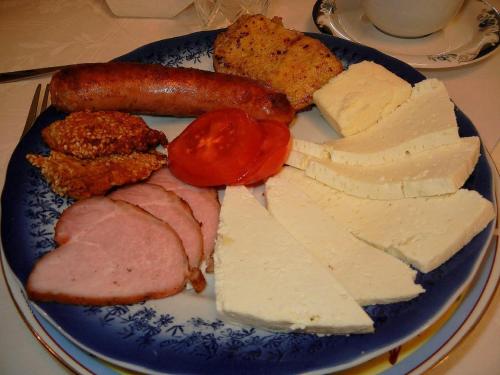 a blue plate of food with meats and cheese at Pensiunea Casa-Stefanel in Sadova