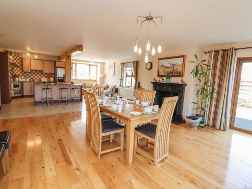 una sala da pranzo e una cucina con tavolo e sedie di Kissane's Cottage a Beaufort