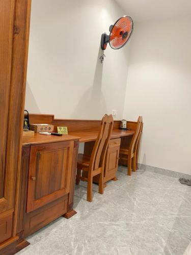 a desk with two chairs and a lamp on the wall at Lộc Sơn Hotel in Buon Ma Thuot