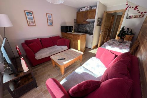 a living room with a red couch and a table at Signal 308 apartment 6 person in Aime-La Plagne