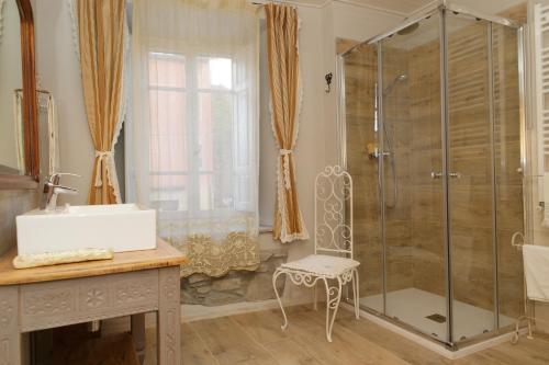 a bathroom with a shower with a sink and a chair at Casa Pini Rio_B in Riolunato