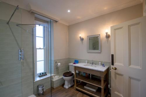 a bathroom with a sink and a shower and a toilet at Garden Wing, Redisham Hall in Beccles