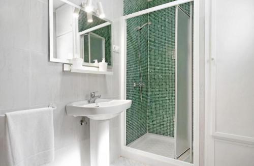 y baño blanco con lavabo y ducha. en Villa Montenmedio 1, en El Soto